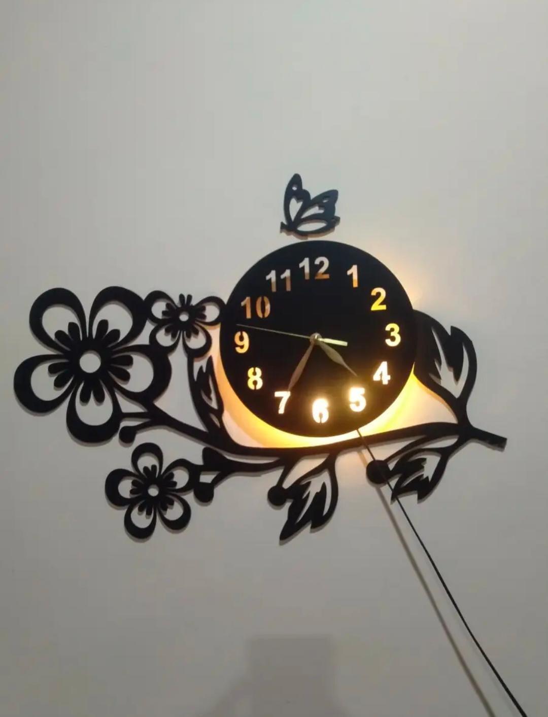 Close view of black flower and butterfly wall clock with warm light