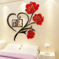 Heart-shaped red rose wall art with two photo frames above a bed