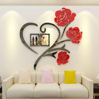 Red rose wall art with two photo frames displayed above a sofa