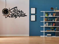 Black Arabic calligraphy HasbunAllah wall clock shown beside blue accent wall