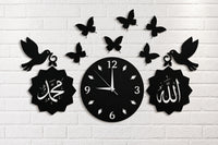 Black 3D Islamic wooden wall clock with Allah and Muhammad calligraphy, birds and butterflies on white brick wall