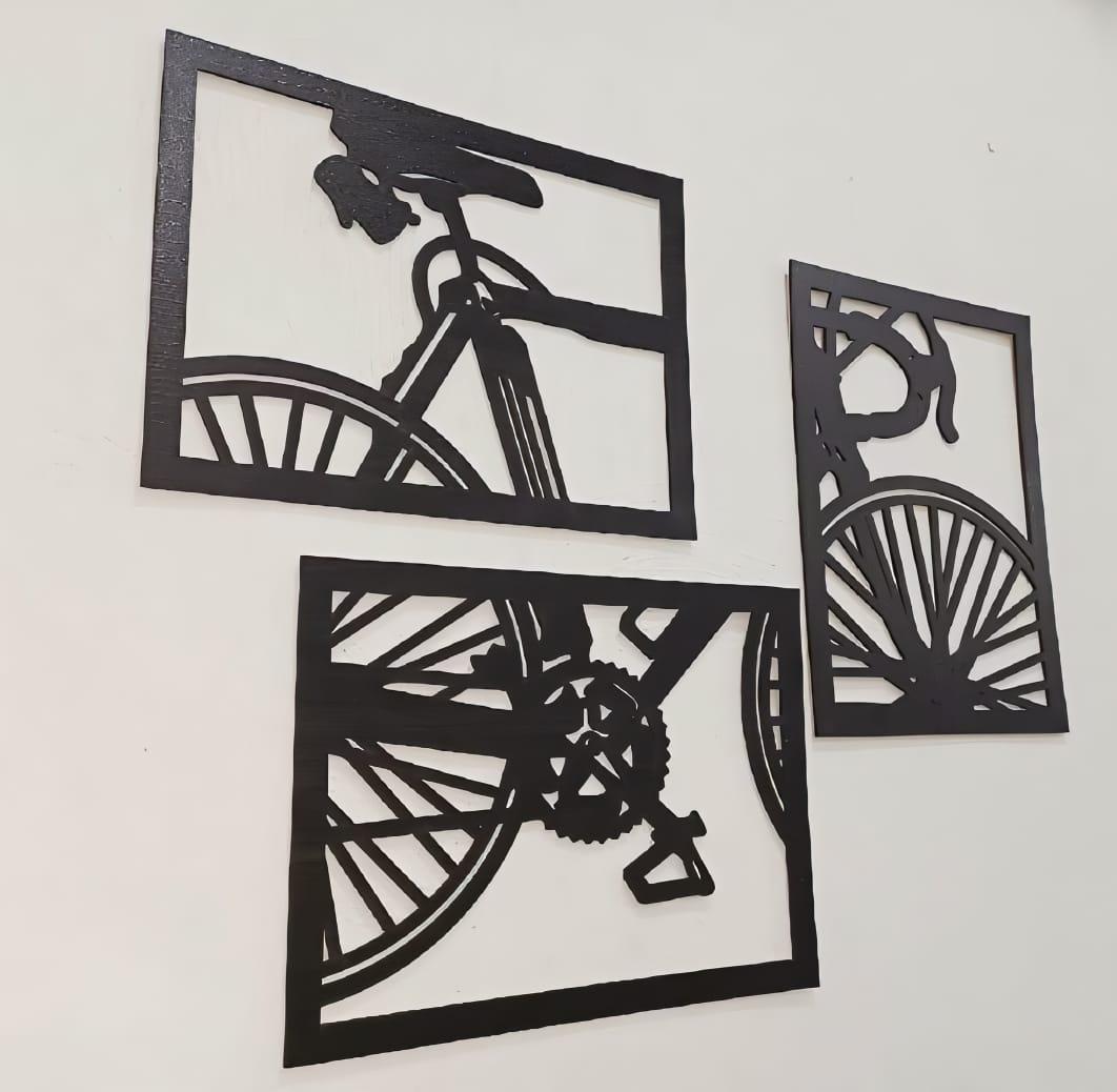 Angled view of the three-piece black bicycle wall art