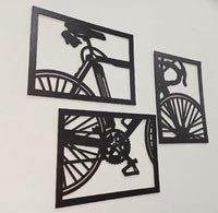 Angled view of the three-piece black bicycle wall art
