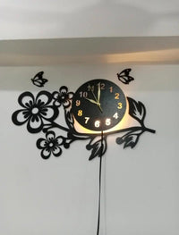 Black floral wall clock with LED glow in room