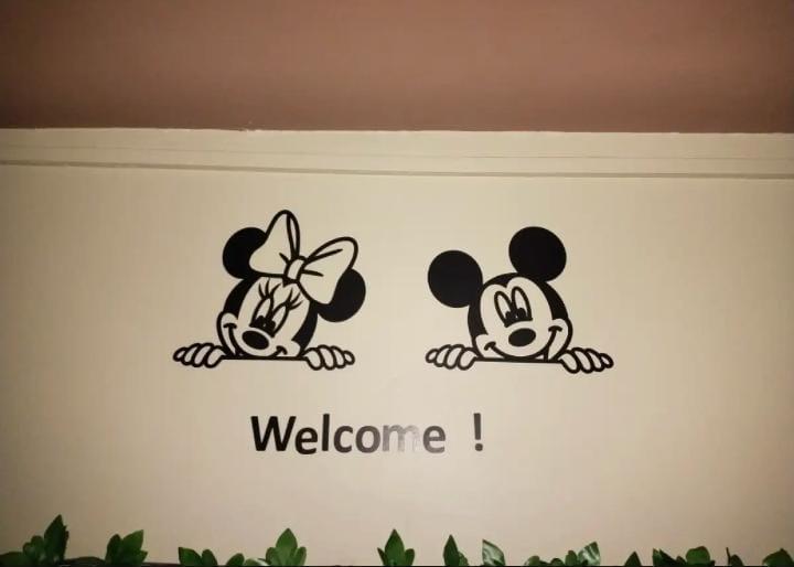 Black mouse-character Welcome wall art displayed in a room