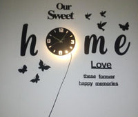 Front view of illuminated Our Sweet Home decorative wall clock