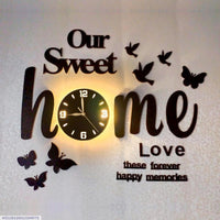 Black Our Sweet Home clock with warm glow mounted on living room wall