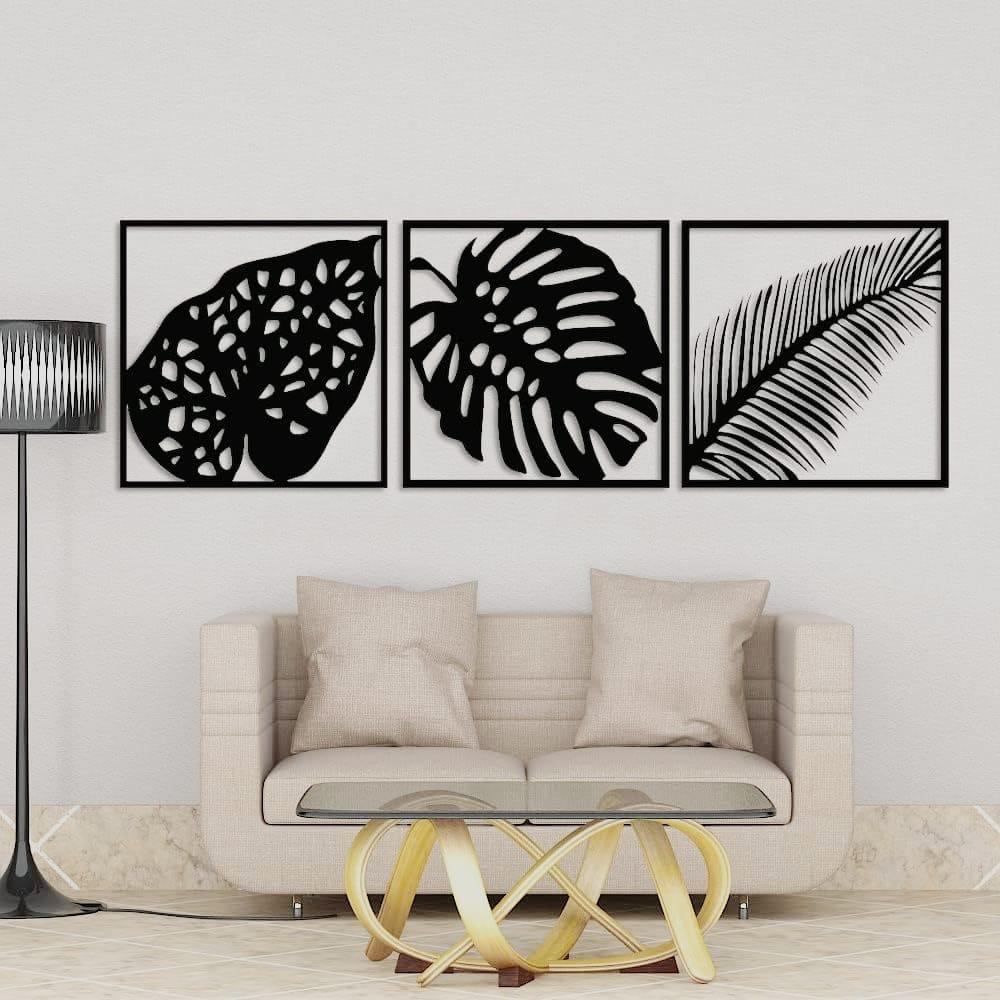 Set of three black leaf wall art frames above a blue sofa