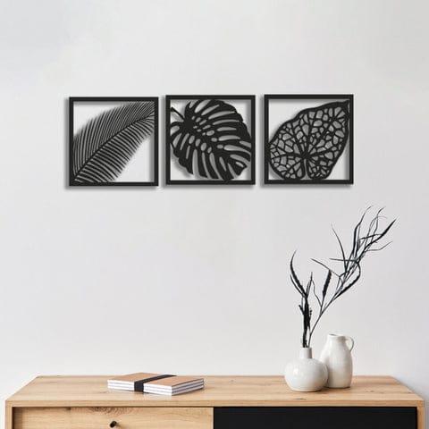 Black leaf wall art set of three displayed above a cream sofa