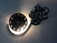 Close view of black Subhan Allah wall clock with warm backlight